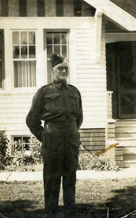 William Headridge standing in front of likely Essondale Cottage 118 in uniform