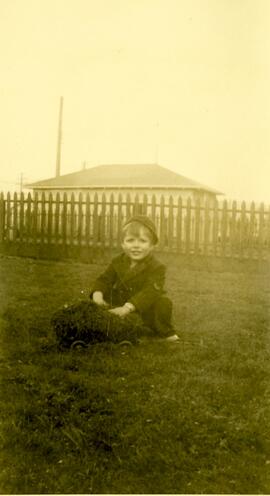 Young boy sitting in the grass