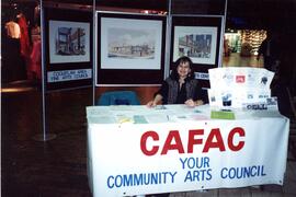 CAFAC staff member sitting at a booth