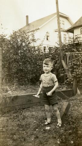 Brian Bovet holding a bugle and a stick in a yard