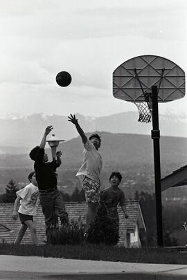 Boys playing basketball above mountains on Panorama Drive