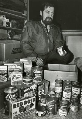 Man with an abundance of non-perishable food items
