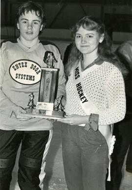 Hockey player and Miss Hockey with trophy
