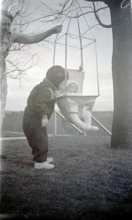 Ida May Headridge and Brian Bovet pushing a baby on a swing