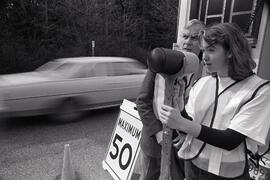 Students try speed gun at speed watch van in front of Charles Best School