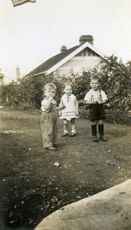 Two children and Brian Bovet standing behind likely Essondale Cottage 118