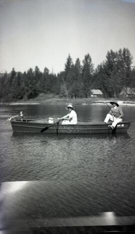 Two people fishing in a boat on a lake