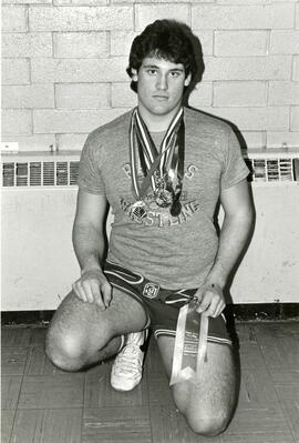 Wrestler posing with multiple medals
