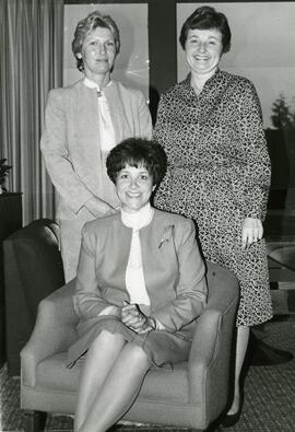 Three women posing in front of window