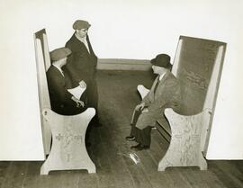 Workers sit on plywood benches