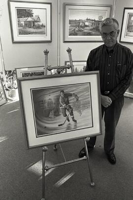 Artist James Lombers with print of hockey greats