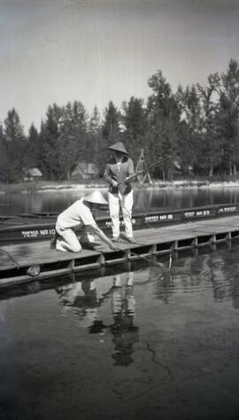 Two people fishing on a dock
