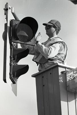 Cobra Electric employee tightens bolts on traffic signal on Lansdowne Ave. in Coquitlam