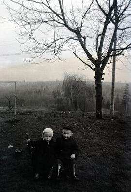 Brian Bovet and child sitting in a yard in winter