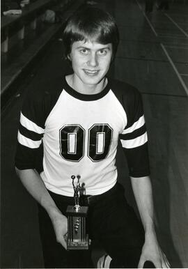 Man posing with basketball trophy