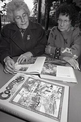Seniors look over Coquitlam Centennial book at Dogwood Pavilion