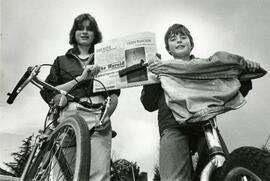 Two teens on bikes delivering newspapers