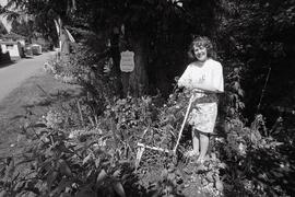 Marypat Johnston and her pussycat Blossom in her garden at 405 Laurentian Crescent