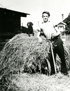Cap Hobbis with a dog on a hay bale