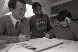 Sunny Chan and his family, colouring around the kitchen table