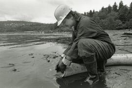 Worker releasing material into the ocean from a hose
