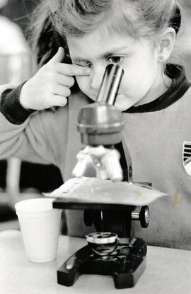 Christina Bernicki a grade one student at Ranch Park Elementary school examines a piece of wax paper that has dust particles from a typical home.