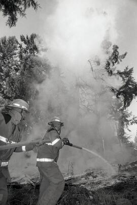 Sasamat Fire personnel extinguishing a fire at an abandoned mobile home on East Road