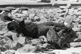 Unidentified man sleeping on rocks at Rocky Point Park