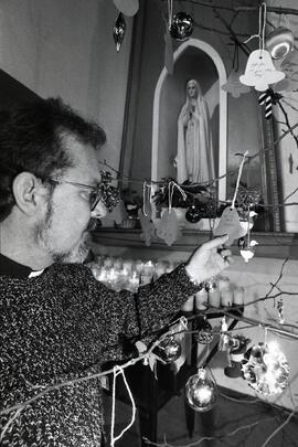 Father Craig Scott looks at a few of the gift ideas that still need to be filled on the Tree of Need at the Our Lady of Fatima Church on Walker