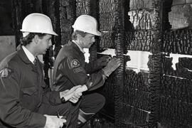 Cat Tim Sylvestri and Ron Bourassa inspect the scene of a fire looking for arson.