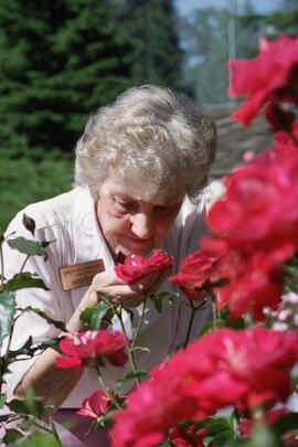 Ann Cox smelling roses at the Dogwood Rose Garden