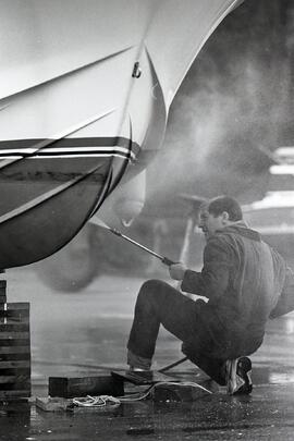 Ron Aitken washes away a winter's worth of grime from his 28 ft. cruiser, R & R, at Reed Point Marina