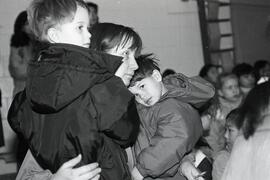 Roy Stibbs students getting on bus that will take them to their new school. - Mother hugging kids at morning assembly.