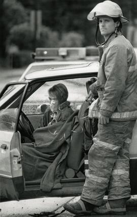Firefighter Greg Nyhaug runs oxygen to accident victim, while they wait for ambulance.