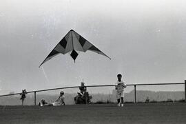 Philip Atizando and Tom Methven flying a stunt kite at Panorama Park Elementary School