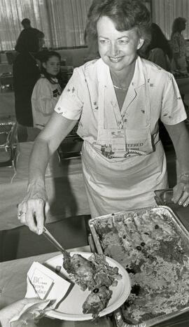 Myrna Herms dishes up another meal at the athlete's village.