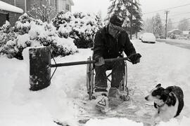 Vic Clark shovels snow in his wheelchair