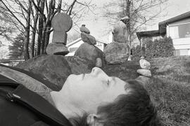 Michael Gerow balances a rock on his nose in front of a number of his other sculptures
