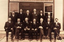 Group of suited gentlemen in front of a building