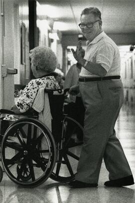 Man pushing a patient in a wheelchair