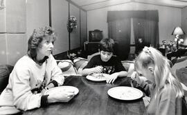 Amanda Coulter and Fred (12) and Alexis (9) sit down to dinner in their trailer