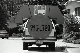 Summer student employment officers in a car decorated like a giant telephone as an advertisment