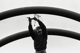 Electrician Ian Bruce strings wires in decorative steel arches at Coquitlam's new acquatic centre