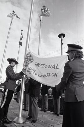 RCMP constables take down anniversary flag at Coquitlam Recreation Centre