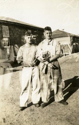 Two workers standing near Essondale store houses