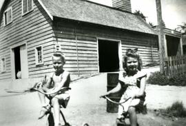 Two children on bikes outside the Municipal Hall Garage at 1121 Brunette Ave