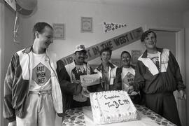 Special Olympic athletes that won medals gathered around a cake