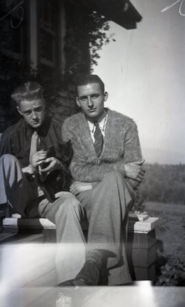 John Headridge and Doug seated with a black cat on the steps of likely Essondale Cottage 118